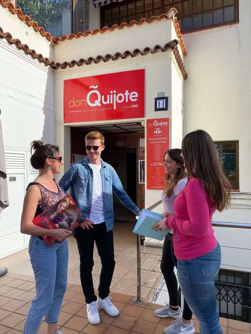 Students conversing outside a language school, don Quijote, possibly in Spain.