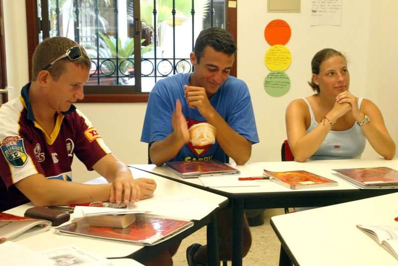 Studenten volgen een taalcursus in een lokaal.