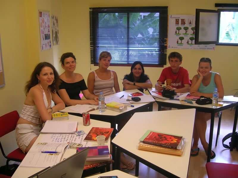 A group of students attending a language class, study materials present.