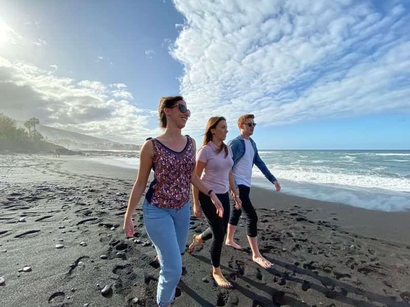 Three people enjoying a beach walk, possibly language immersion travel program.