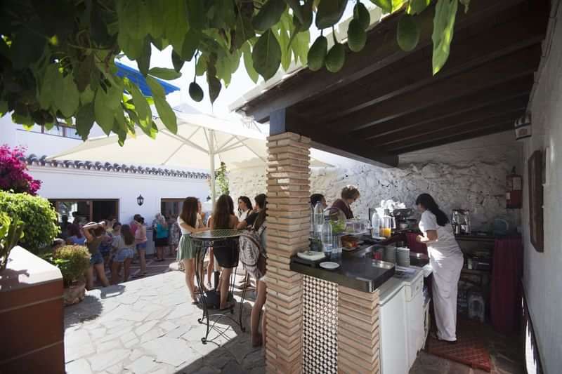 A group enjoying refreshment outdoors, likely in a language immersion setting.