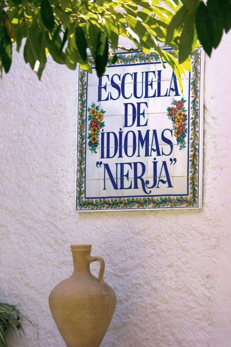 Language school sign in Nerja, designed with floral border.