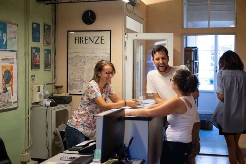 Studenten en medewerkers praten in een taalschool in Florence, Italië.