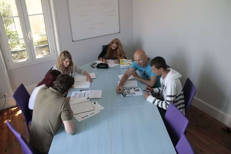 Studenten in groepsles leren nieuwe taal in studieruimte.
