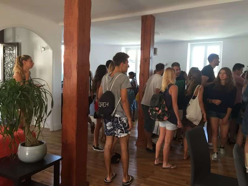 Students socializing in a language school common area, preparing to travel.