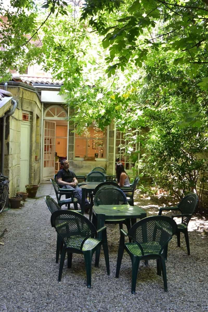 Outdoor cafe where travelers practice languages in a picturesque setting.
