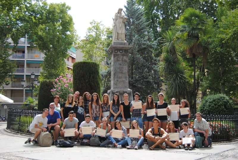 A group of students on a language travel excursion posing with certificates.