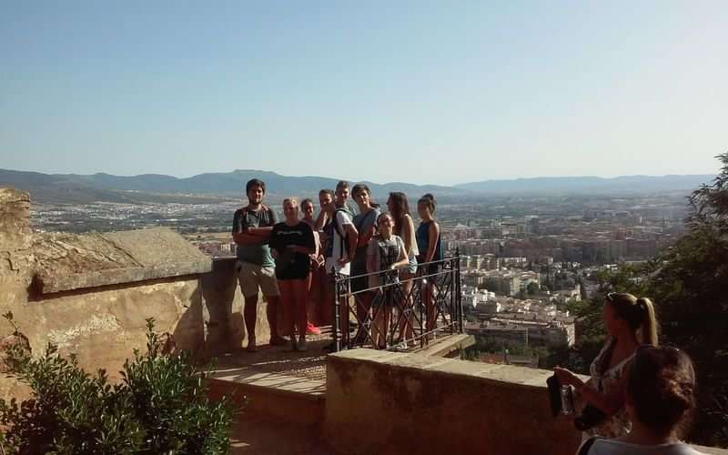 A group exploring a historical site with a city view.
