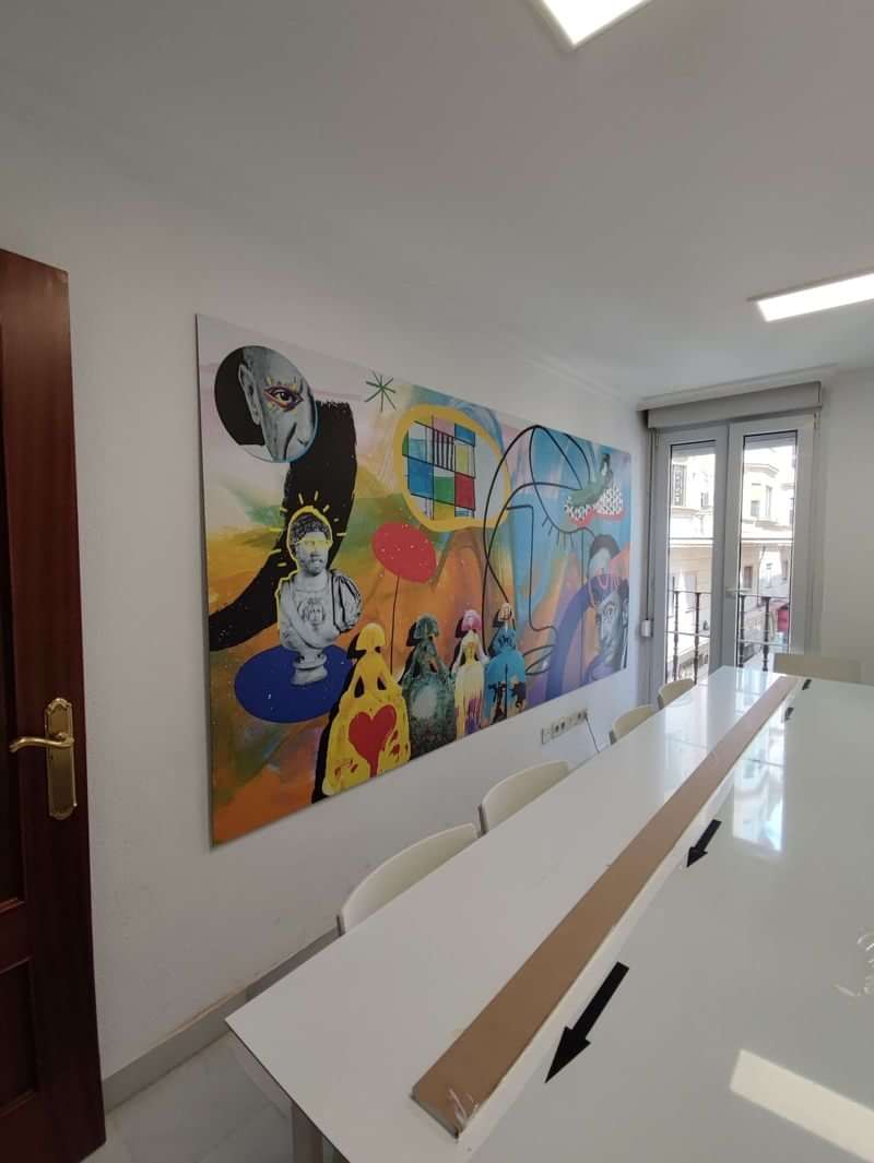 Colorful mural in language school classroom with large windows and white desks.