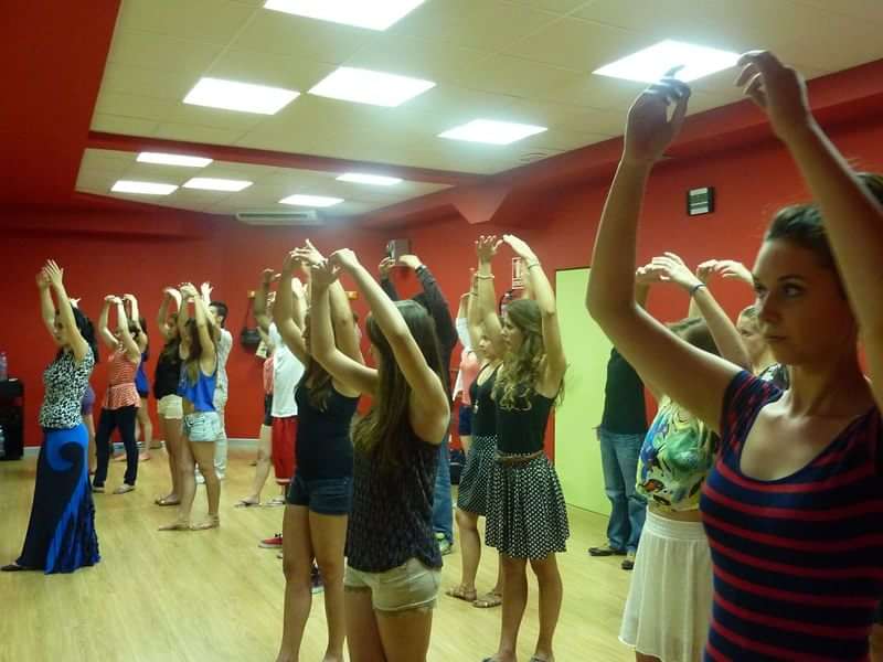 Group dance class, immersive cultural experience, language learning through movement.