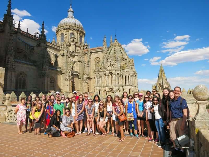 Group of students on an educational tour in front of cathedral.