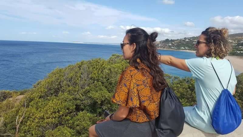 People enjoying a scenic coastal view, potentially during a language travel adventure.