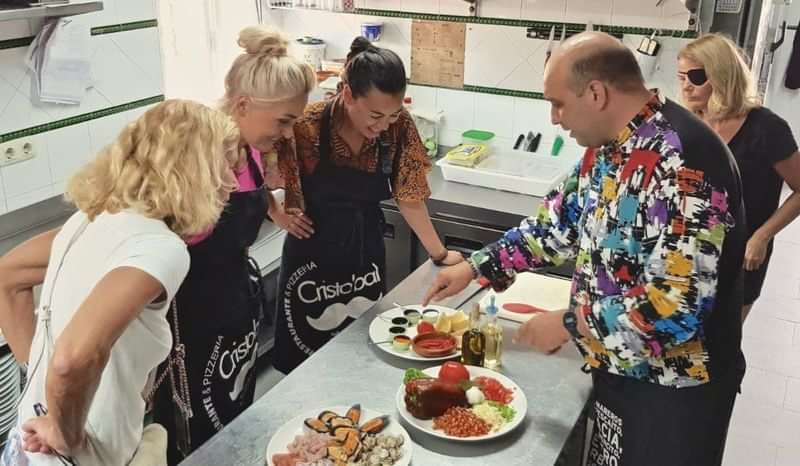 Cooking class participants learning local cuisine in a kitchen setting.