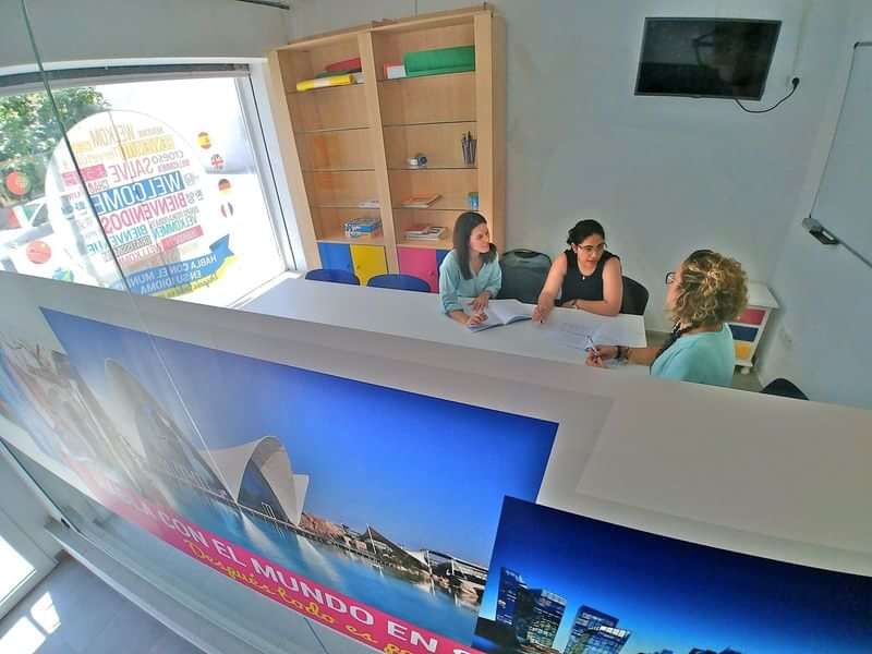 People discussing at a travel or language school office.