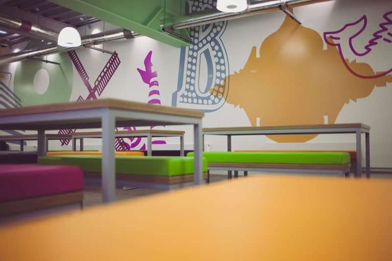 Classroom with colorful benches and walls decorated with alphabet letters.