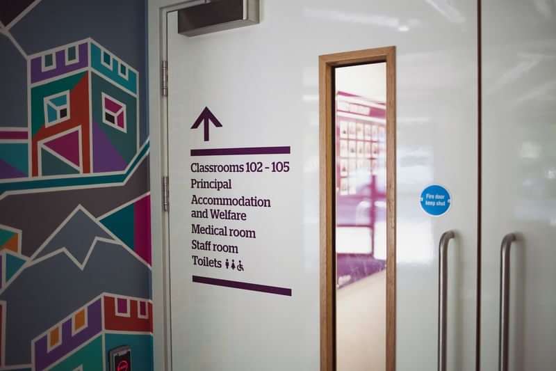 Sign directing to classrooms, accommodation, medical room, staff room, and toilets.