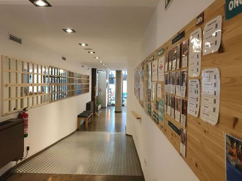 Lobby van een talenschool met informatieve prikborden en wachtruimte.