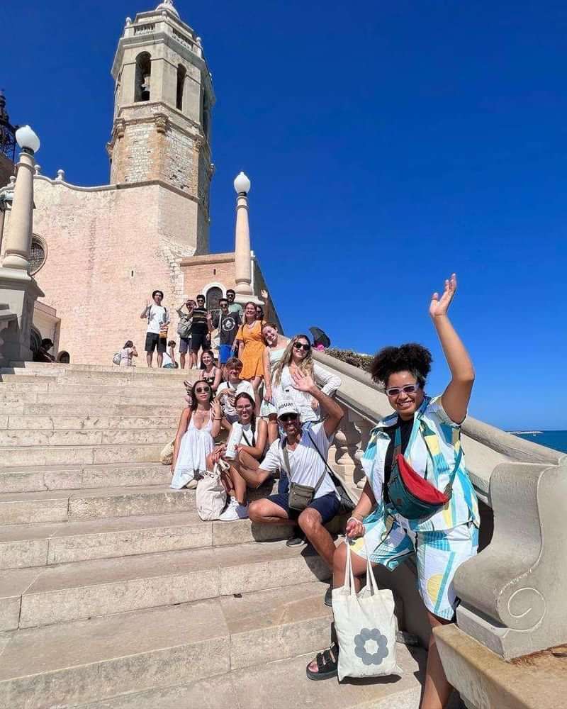 Groep toeristen voor een historische kerk, genietend van hun reis.
