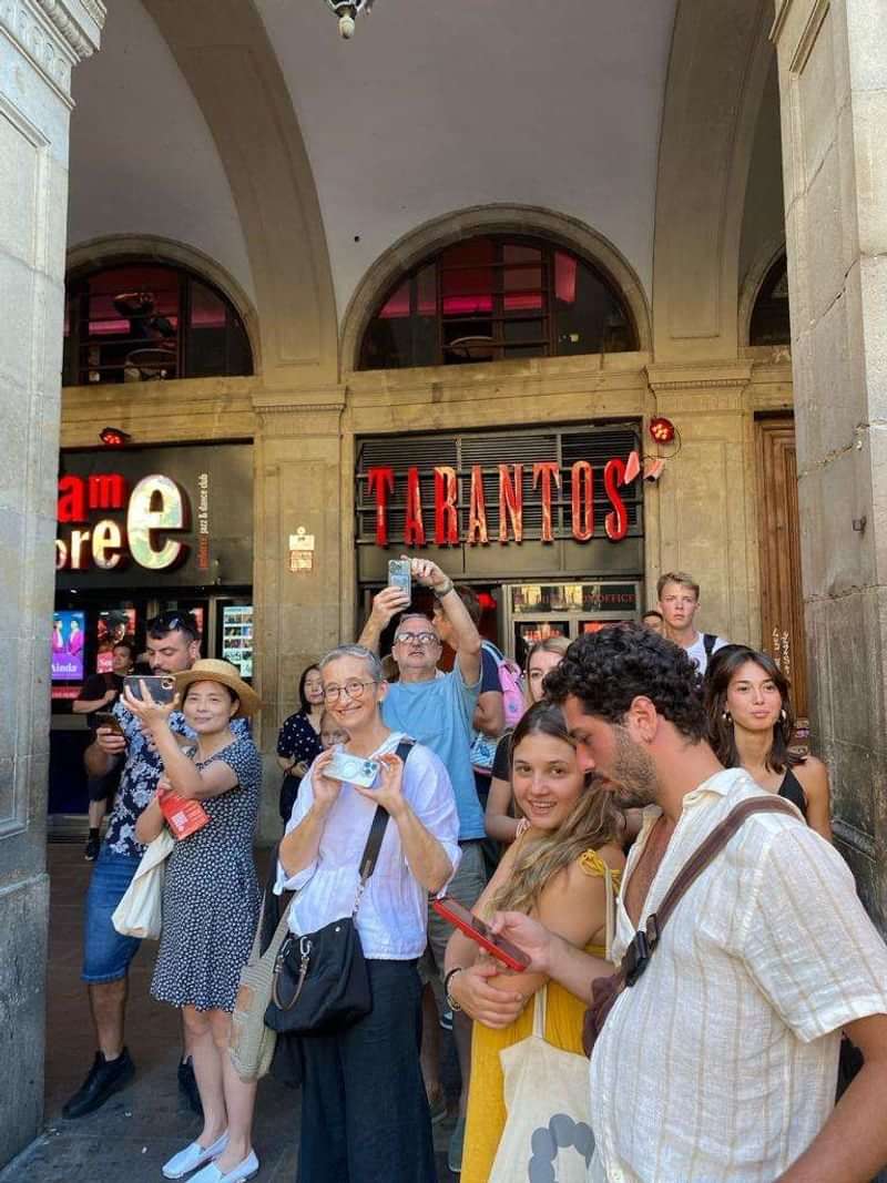 Groep toeristen voor de ingang van Tarantos in een stad.