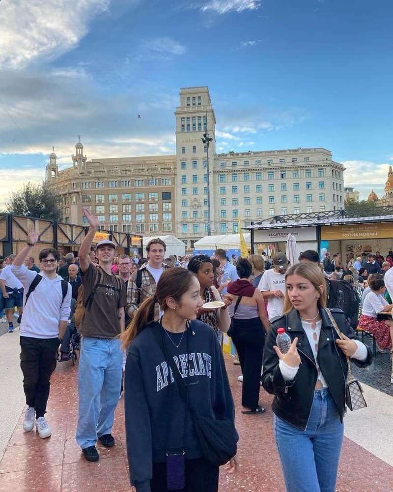 Travelers engaging in immersive language experiences in a bustling city square.