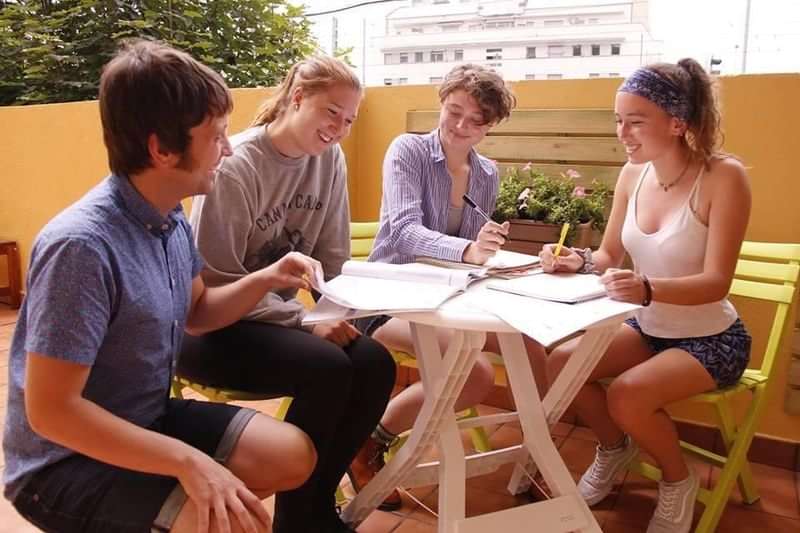 Group of students practicing language skills outdoors during language travel session.