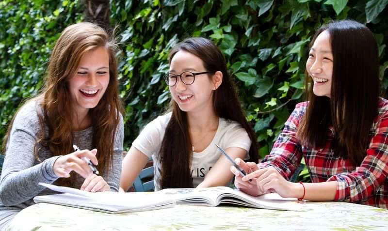 Studenten studeren samen en lachen, leerervaring buitenland.