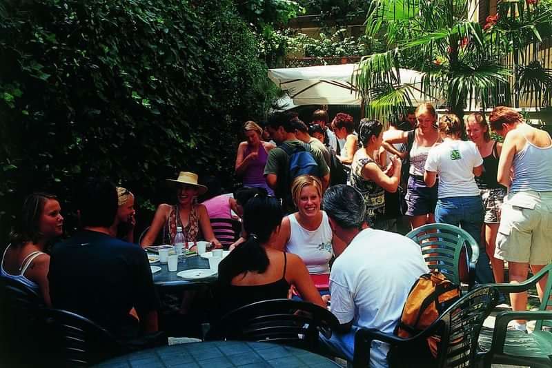 A group of people socializing outdoors, possibly language travel program participants.