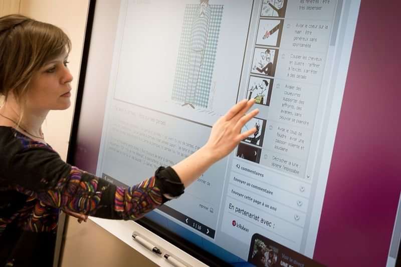 Vrouw gebruikt een interactieve display voor taal- en reisstudie.