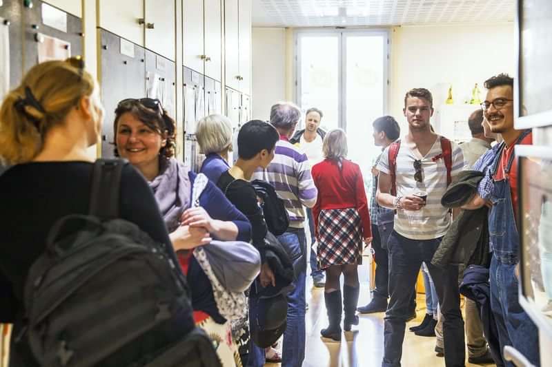 Language students socializing in a school hallway during travel experience.