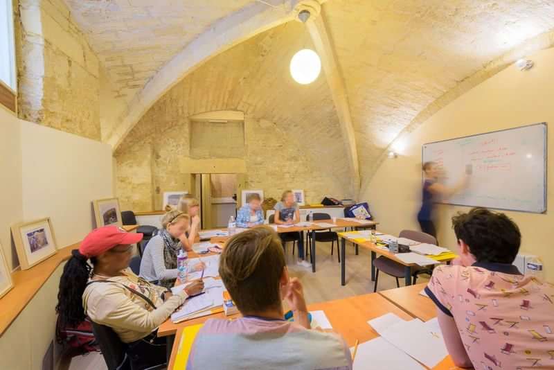 Taalstudenten volgen les in een klaslokaal tijdens een taalcursus in het buitenland.