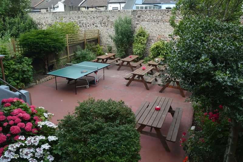 Outdoor seating area with picnic tables and ping pong, ideal for relaxation.