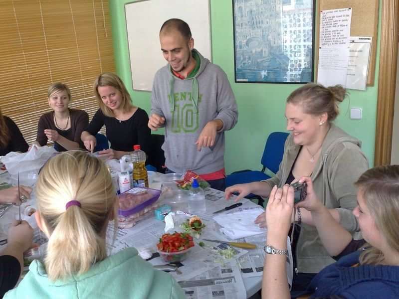 Students in a language class, learning through cooking and conversation.