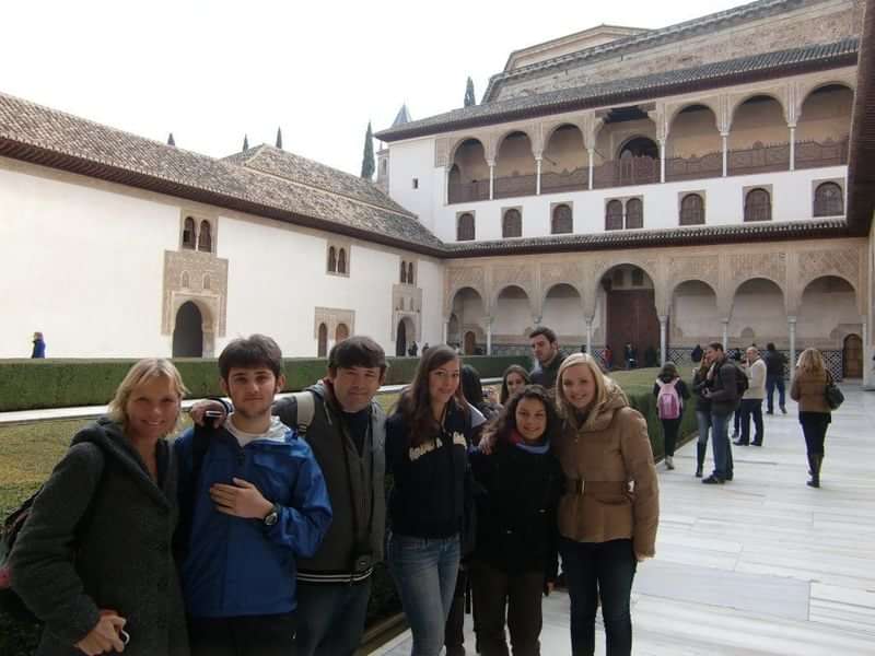 Groepsfoto van studenten voor historische architectuur tijdens taalreis, waarschijnlijk in Spanje.