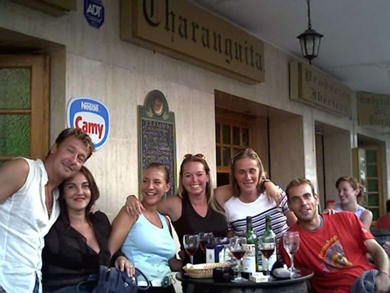 Group of friends enjoying drinks at a café, practicing language skills.