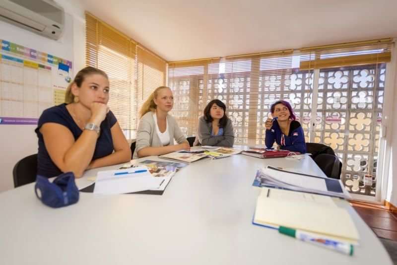 Studenten nemen deel aan een taalles in een klaslokaal.