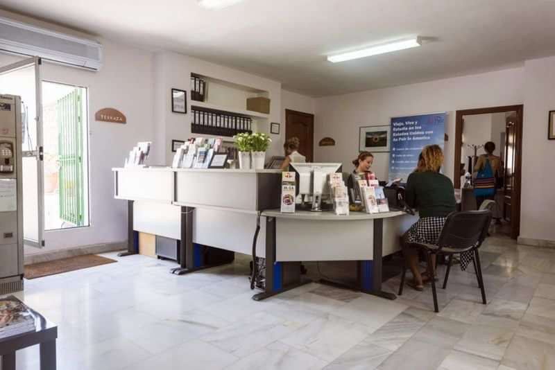 People seeking information at a language travel agency office.