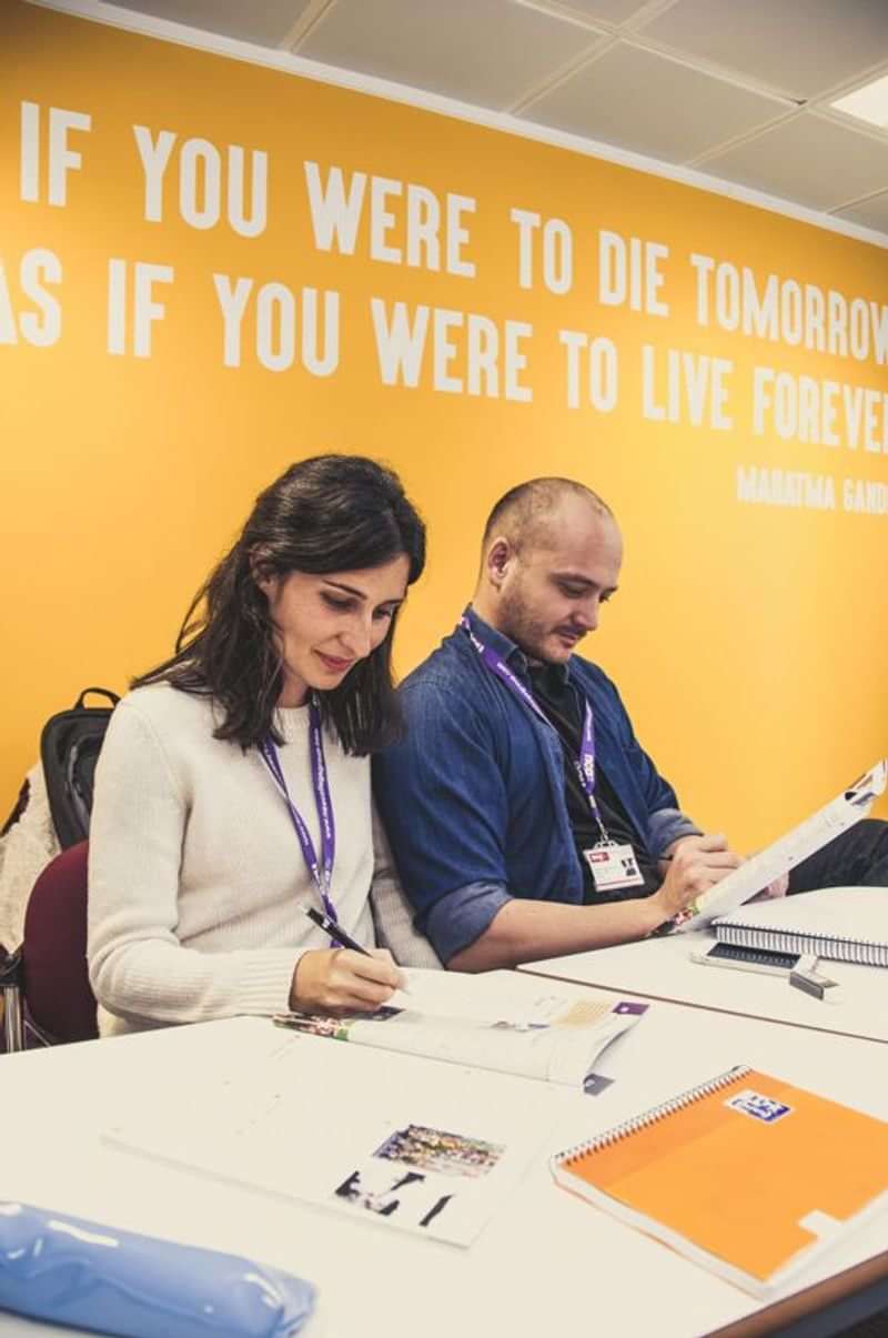 People at a language conference or workshop, name tags visible.