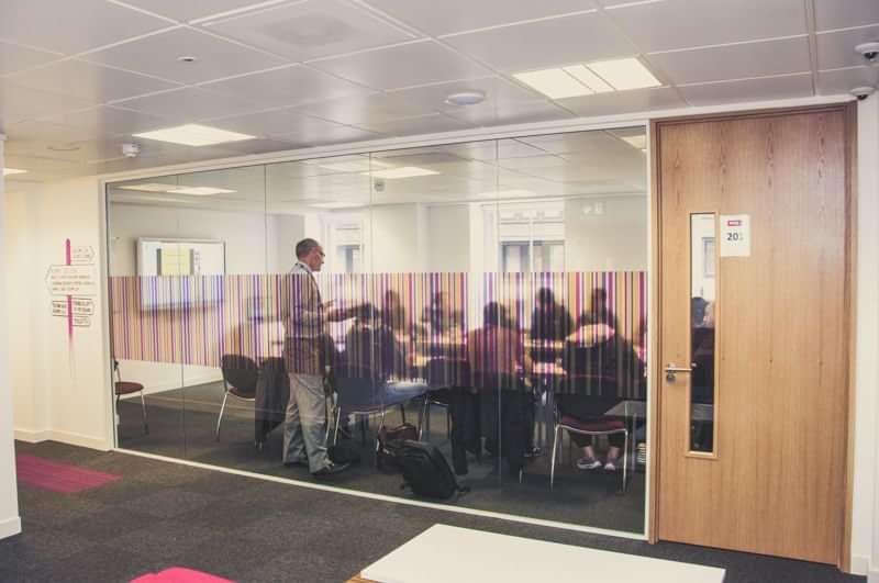 Language class with students and teacher in a modern classroom setting.