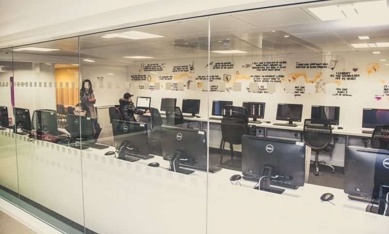 A language school classroom with computers and students, learning space.