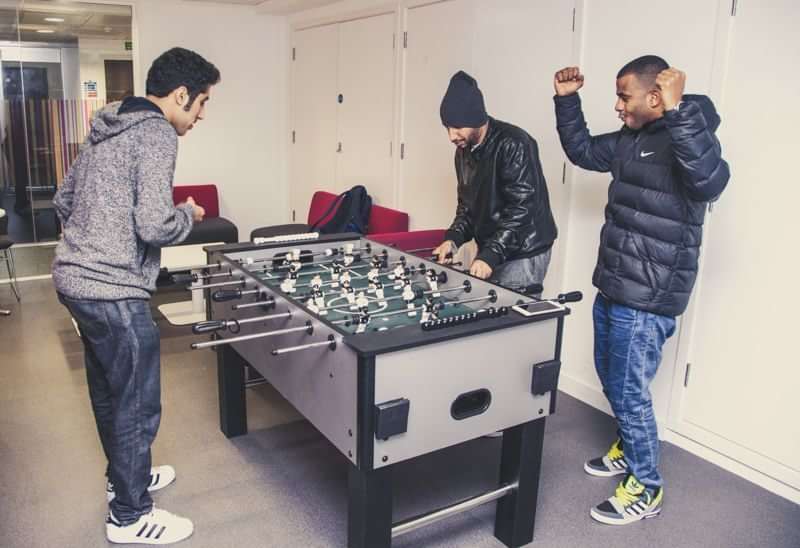 Students enjoying leisure time with foosball during language travel experience.