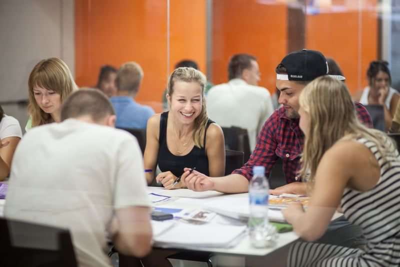 Studenten oefenen samen taalvaardigheden tijdens een studiereis in het buitenland.
