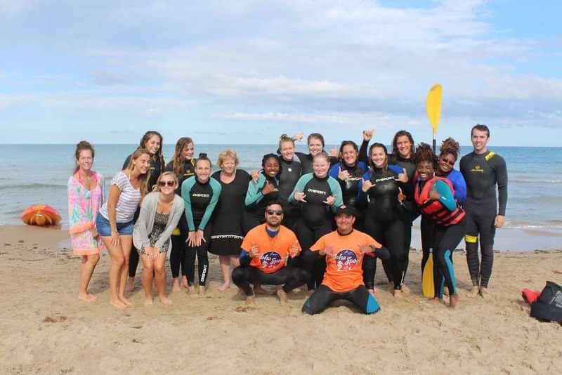 Groep studenten op het strand tijdens taalreis in Nederland.