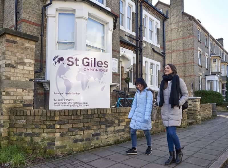 Two people walking by St Giles Cambridge language school.