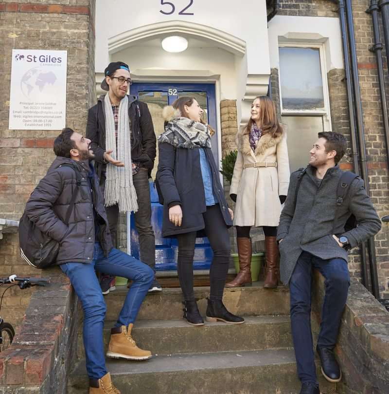 Group of friends talking outside a building, likely during language travel.