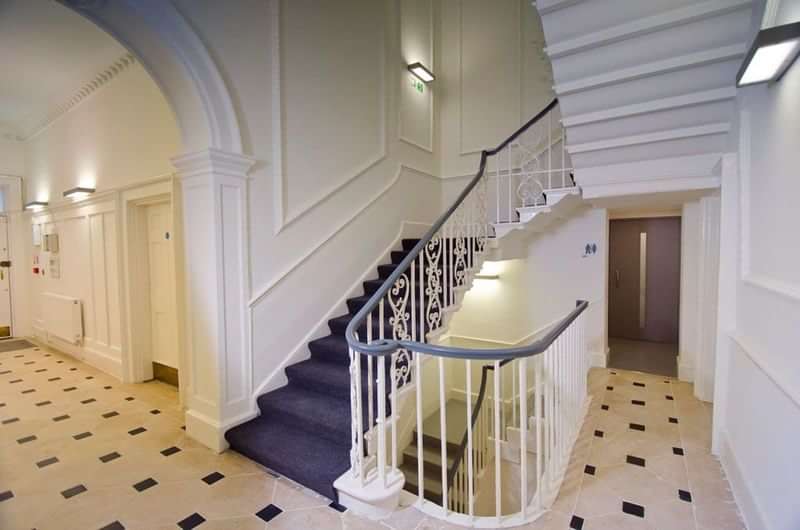 A language school's staircase and hallway in an elegant building.