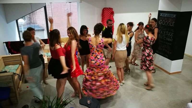 Groep mensen neemt deel aan culturele dansles tijdens taalkundige reis.