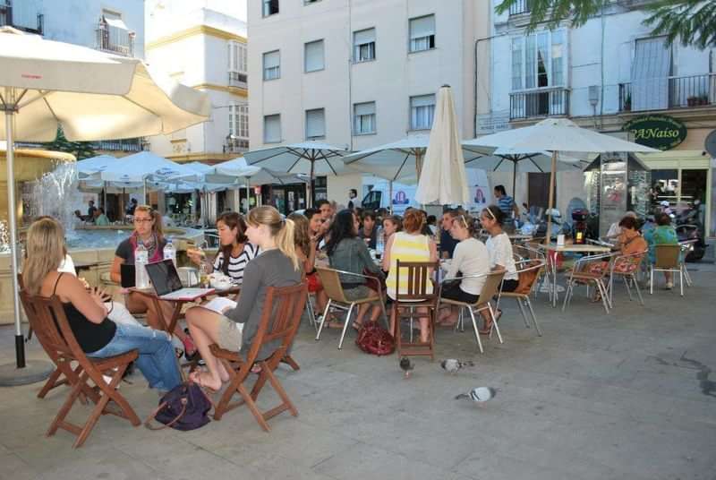Mensen genieten van een drankje op een terras in een stad.
