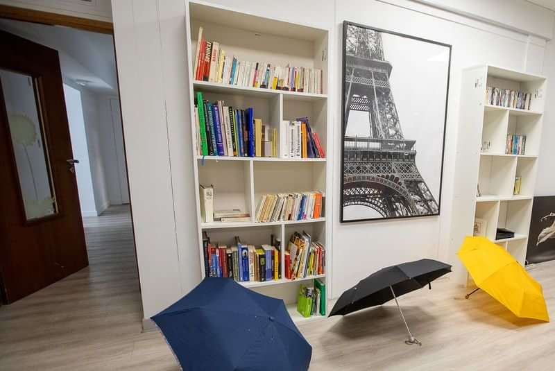 Bookshelves, Eiffel Tower photo, umbrellas; language travel context with French theme.