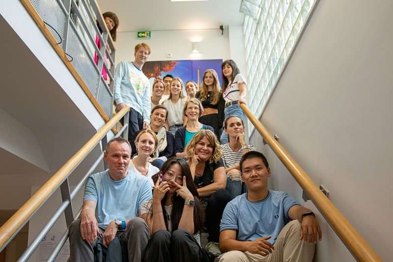 Groep studenten op een trap tijdens taaluitwisseling.