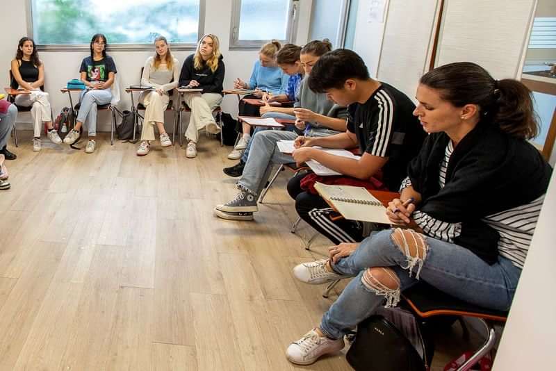 Groep studenten volgt een taalles in modern klaslokaal, Nederland.